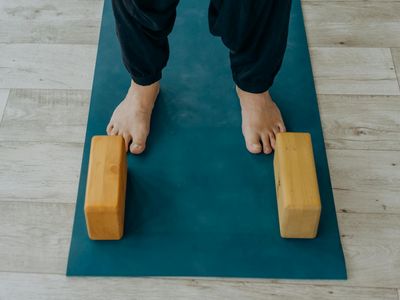 Yoga equipment including a mat and a wooden block.